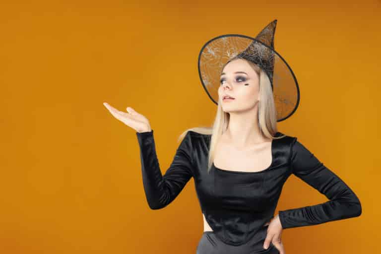 Mujer con maquillaje y disfraz de Halloween sobre fondo amarillo